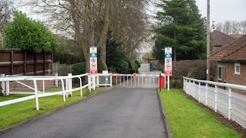 A gated entrance with a stop sign and a no-horse crossing sign.