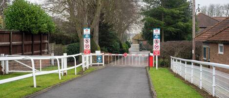 A gated entrance with a stop sign and a no-horse crossing sign.