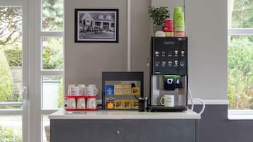 A coffee machine with a selection of coffee pods and a framed black and white photo on the wall.