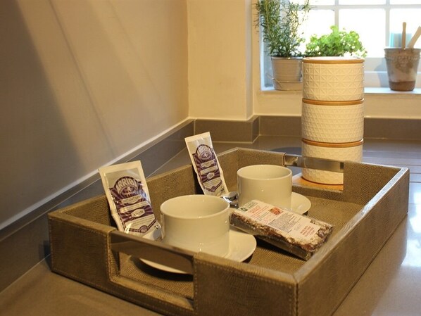 A tray with a beverage, a snack, and a card on a table.