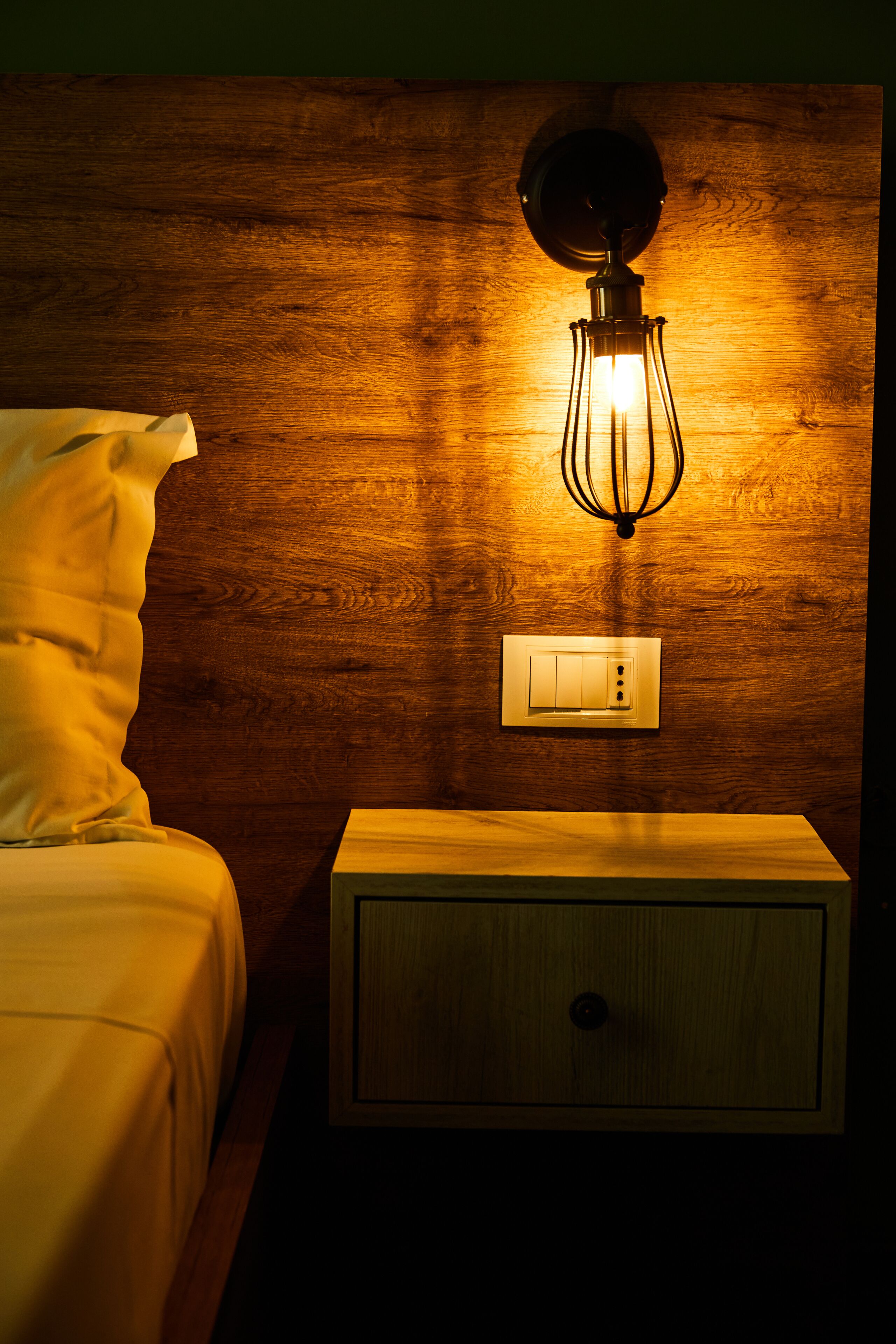 Un mur en bois avec un luminaire et un interrupteur.