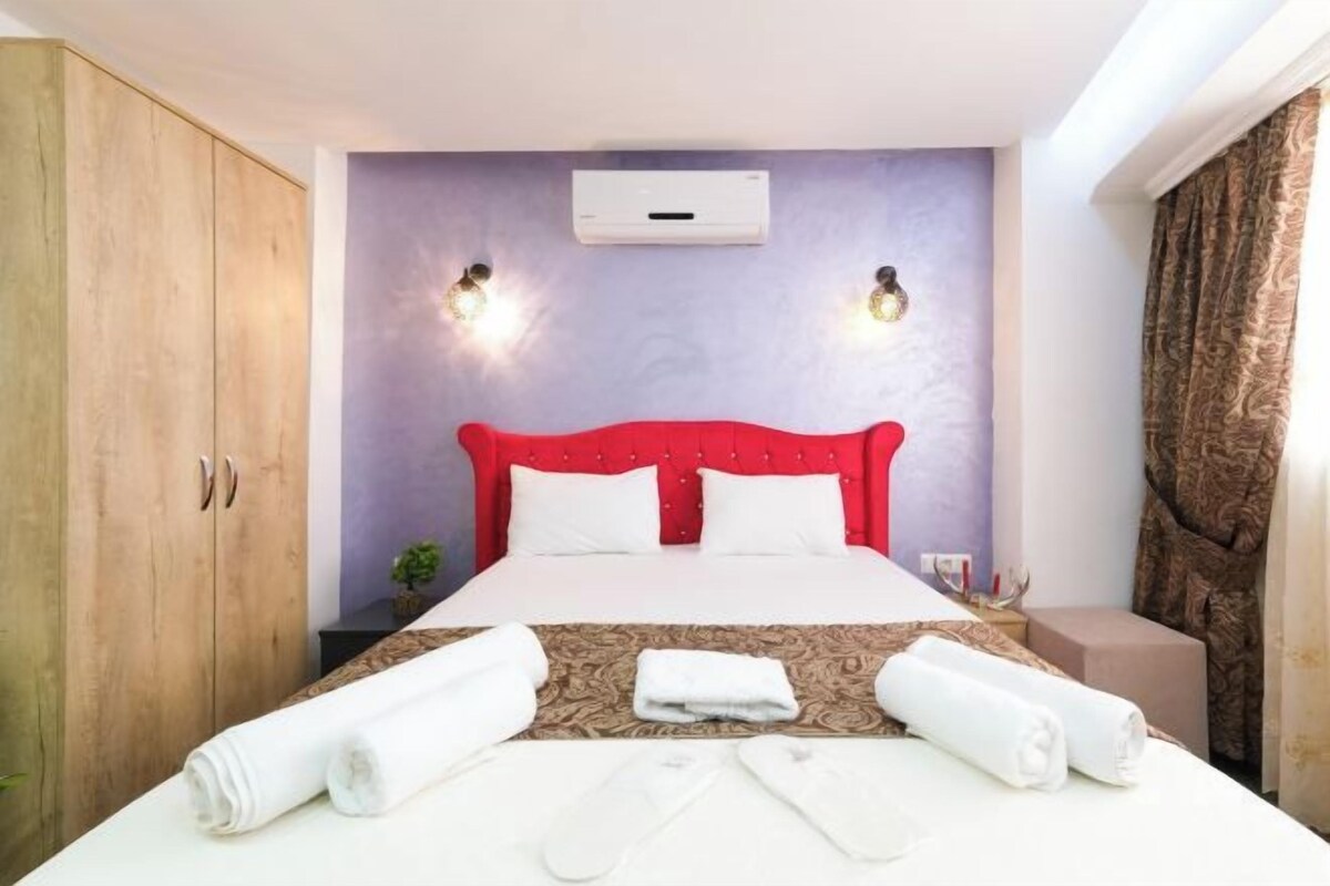 Ein Hotelzimmer mit Bett, Schrank, Klimaanlage und Wandleuchten.