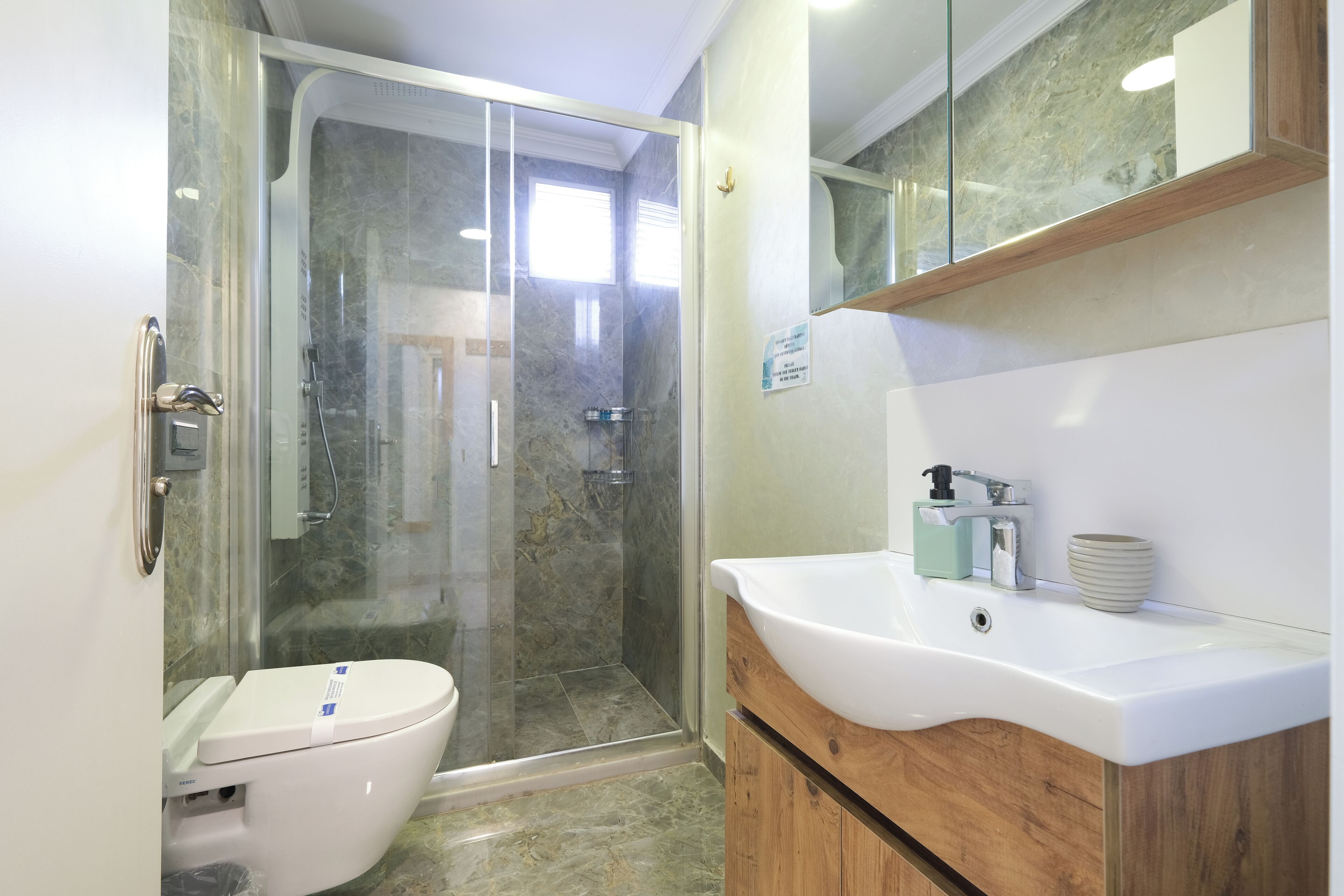 Un baño con ducha, inodoro y lavabo.