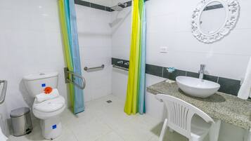 Un baño con inodoro, lavamanos, cortina de ducha y un espejo.