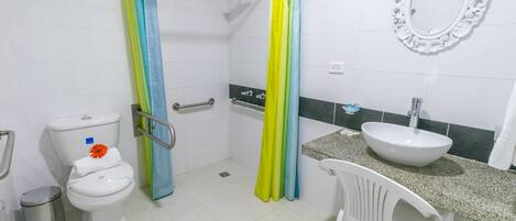 A bathroom with a toilet, sink, shower curtain, and a mirror.