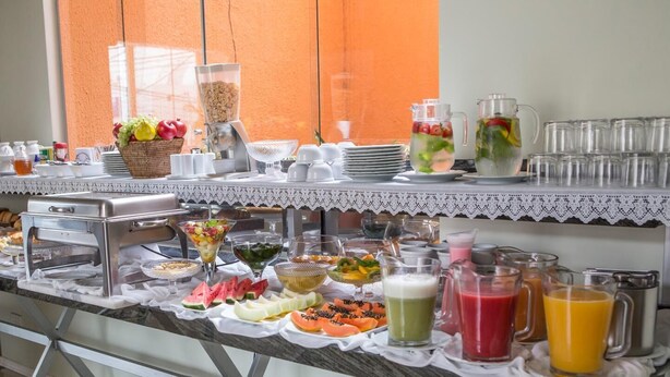 A buffet setup with various food items and beverages. - Hotel Ipanema de Sorocaba (Sorocaba)