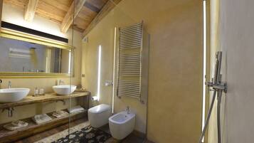 Un baño moderno con dos lavamanos, un bidé, una ducha y un espejo.