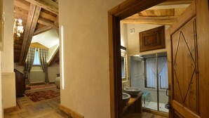 A wooden interior with a staircase, a bathroom with a large mirror, and a view of the outside through a window. - Le Reve Charmant (Aosta)