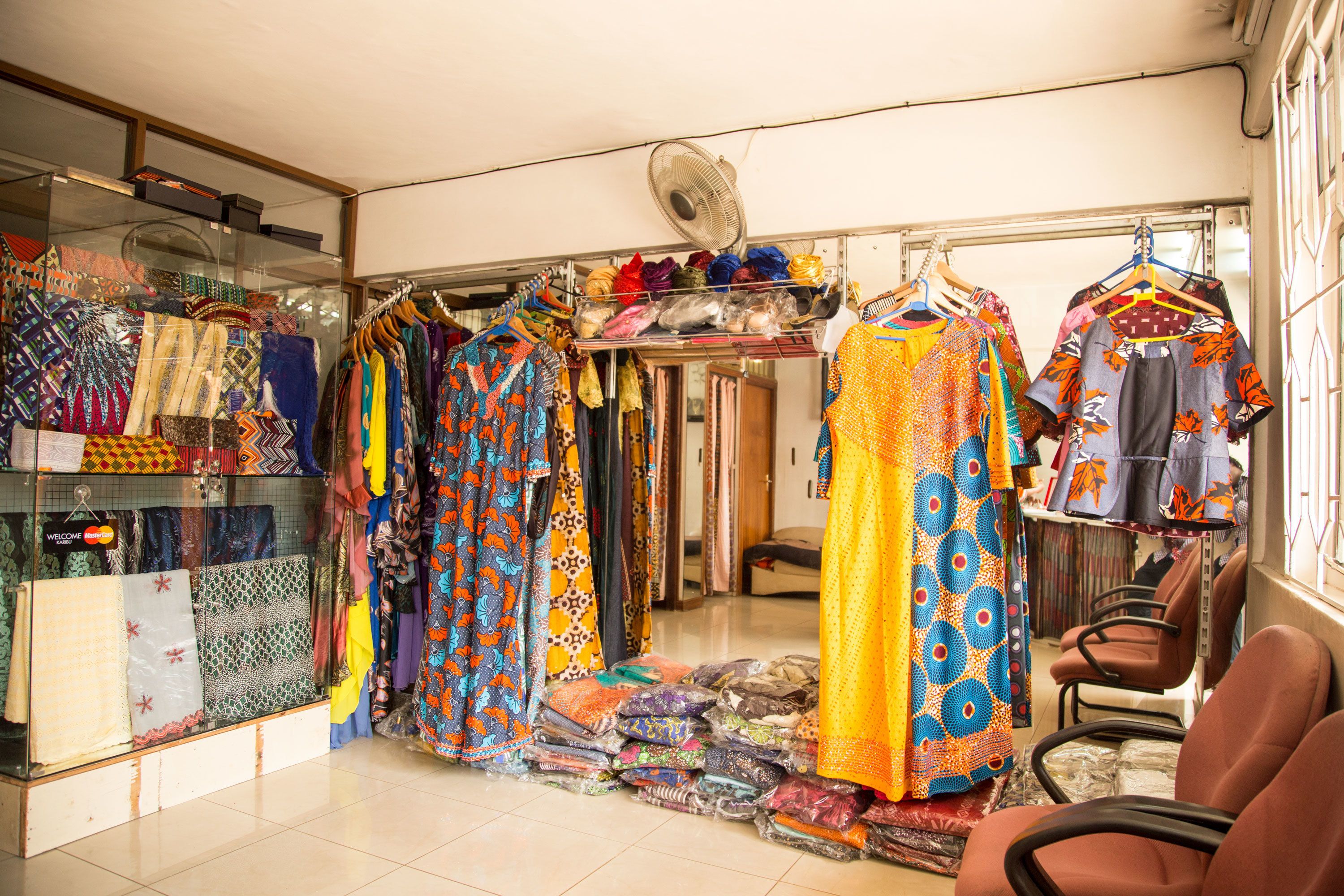 A fabric store with various textiles displayed on racks and tables.