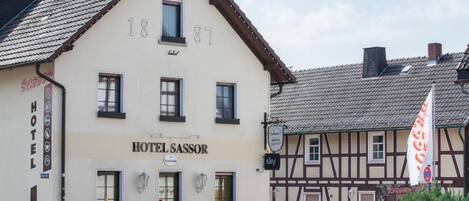 A traditional building with the sign 'HOTEL SASSOR' and a visible entrance.