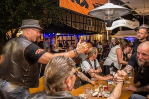 A group of people seated at a wooden table in a restaurant with a traditional European architectural style.