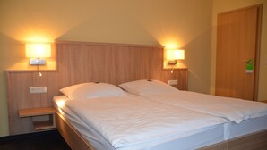 Una cama doble con dos mesitas de noche, cada una con una lámpara de pared.