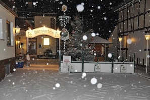 A hotel entrance with a sign reading 'Berggarten' and a Christmas tree in the foreground. - Hotel Sassor (Battenberg)