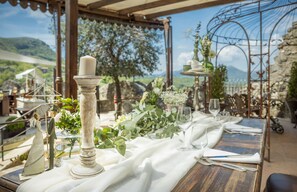 Mesa lista para comer con vista a un paisaje montañoso.