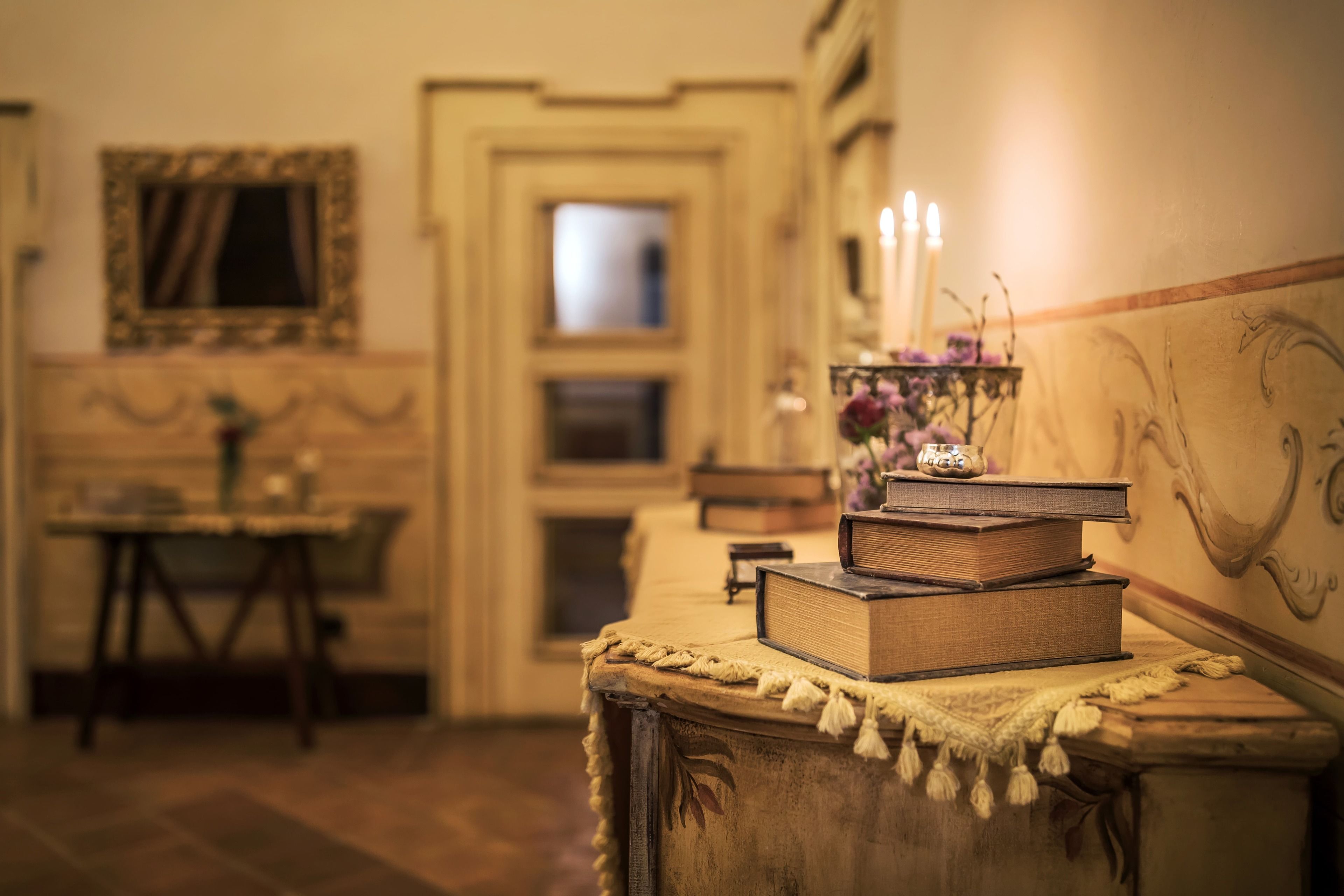 Une pièce avec une table en bois, un miroir et une porte ornée d’un cadre décoratif.