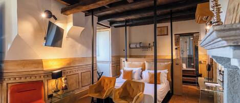A bedroom with a four-poster bed, a red chair, and a wooden ceiling.