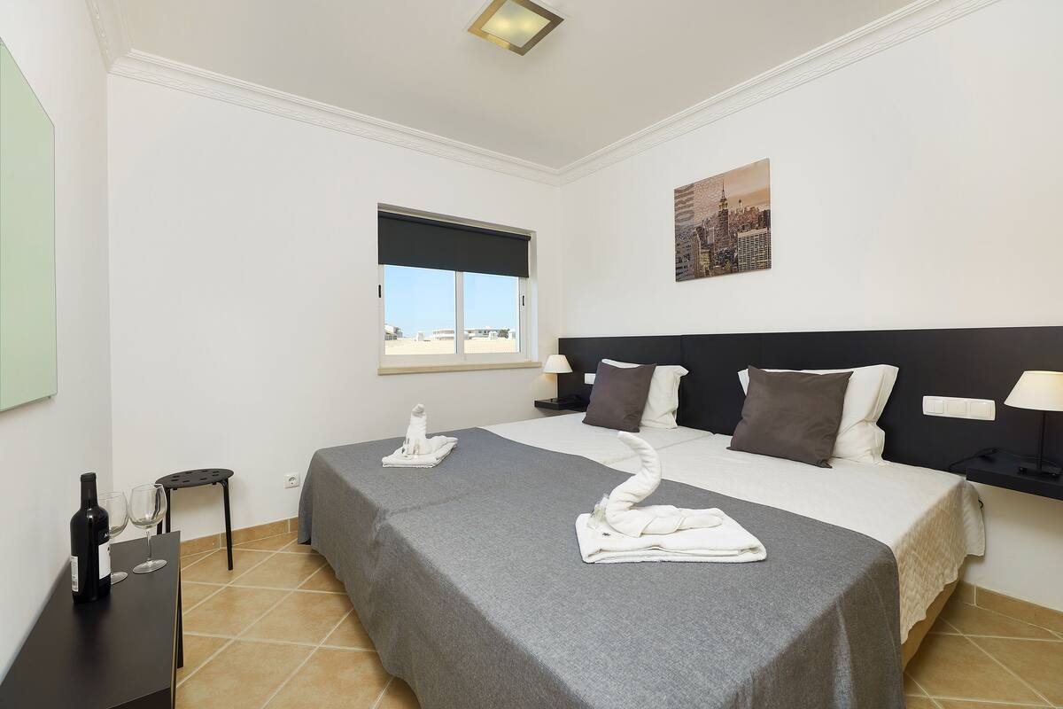 Une chambre d’hôtel avec un lit, une table de chevet, une fenêtre et une vue sur la ville.