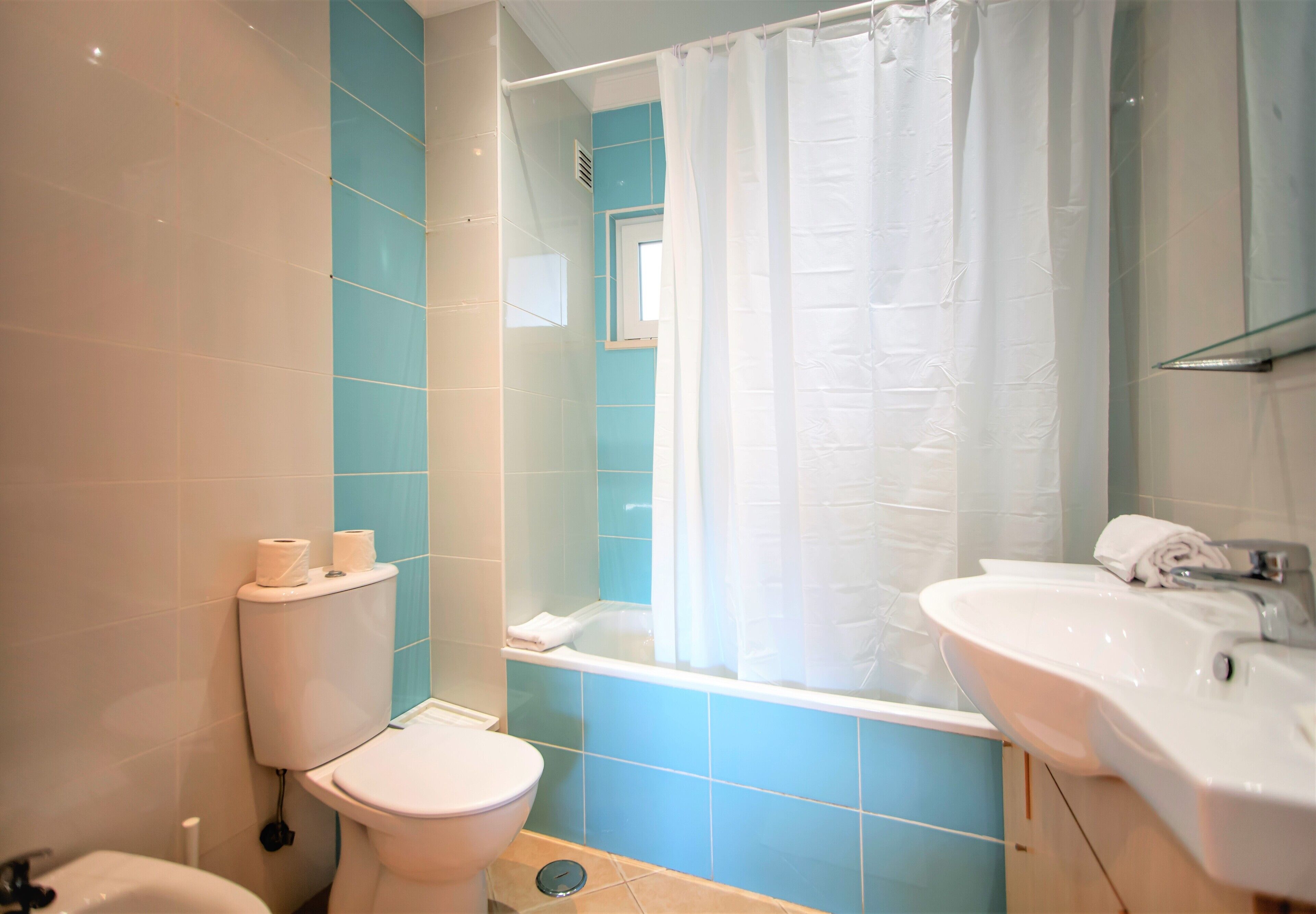 A bathroom with a toilet, sink, and bathtub.