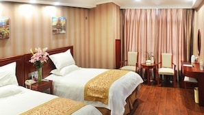 Une chambre d’hôtel avec deux lits, un bureau, une chaise et une petite table.