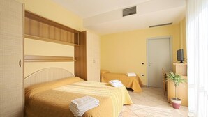 A hotel room with two beds, a wardrobe, a television, and a potted plant. - Residence La Nona (Cervia)