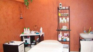 A room with a bed, a desk with toiletries, a shelf with various items, and a sink. - Residence La Nona (Cervia)