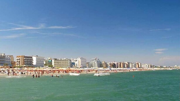 A coastal cityscape with a beach, buildings, and boats. - Residence La Nona (Cervia)