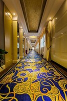 Un pasillo de hotel con alfombra estampada, puertas y ventanas.