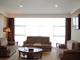 Una habitación de hotel con un conjunto de sofás, una mesa de centro y una lámpara.