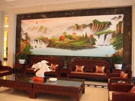 Un vestíbulo con un gran mural de una cascada y paisaje, muebles de madera y un piso de mármol.