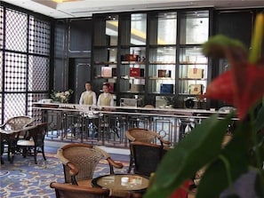 Un área de bar con sillas de mimbre y una barra.
