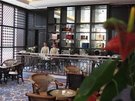 Un área de bar con sillas de mimbre y una barra.