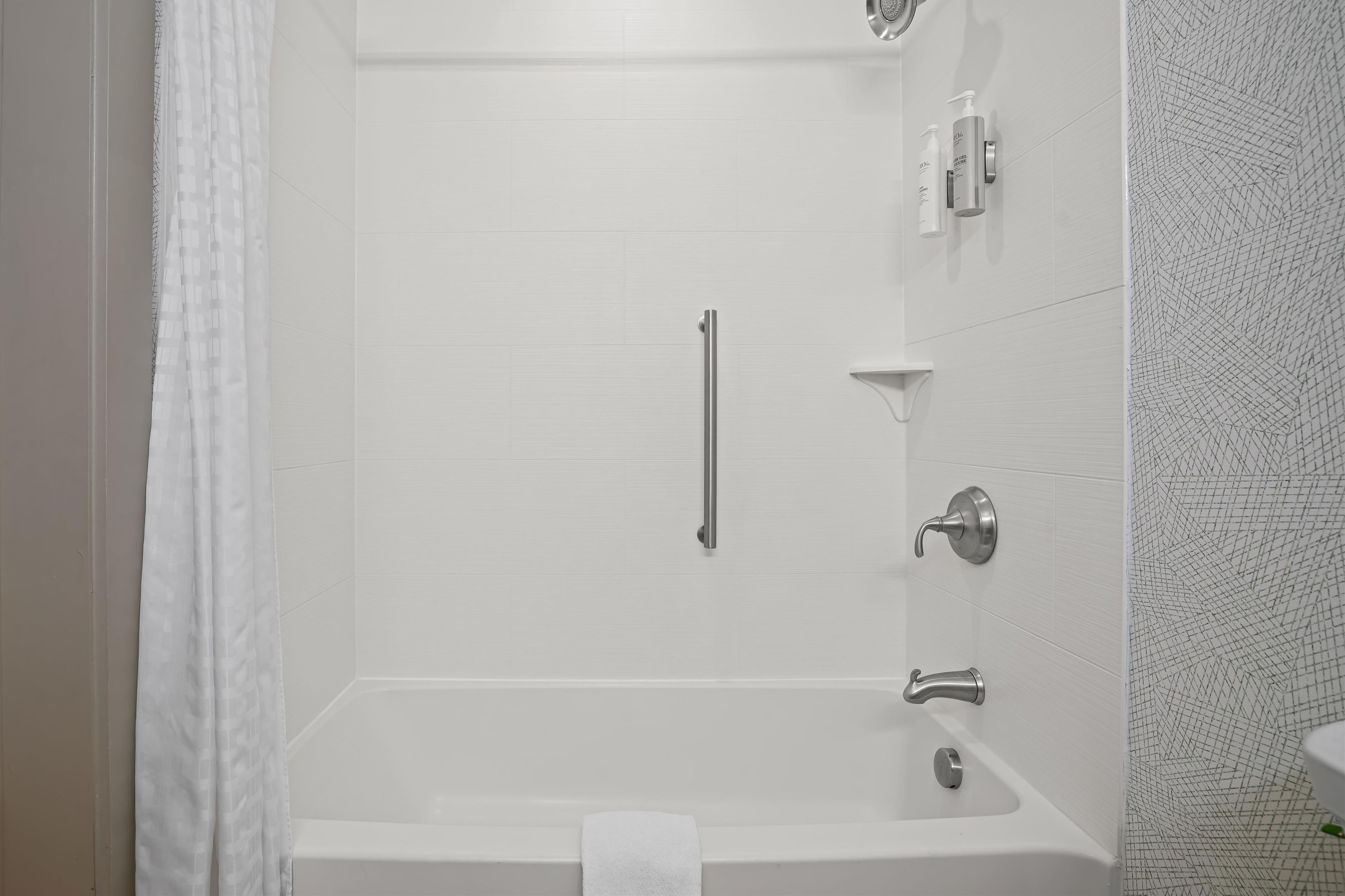 A modern bathroom with a walk-in shower, a bathtub, and a toilet.