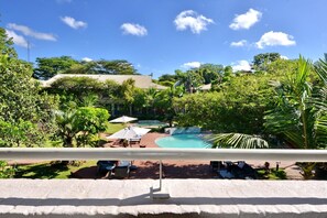 A pool area with lounge chairs and umbrellas, surrounded by lush greenery and trees. - Cresta Lodge Harare (Harare)