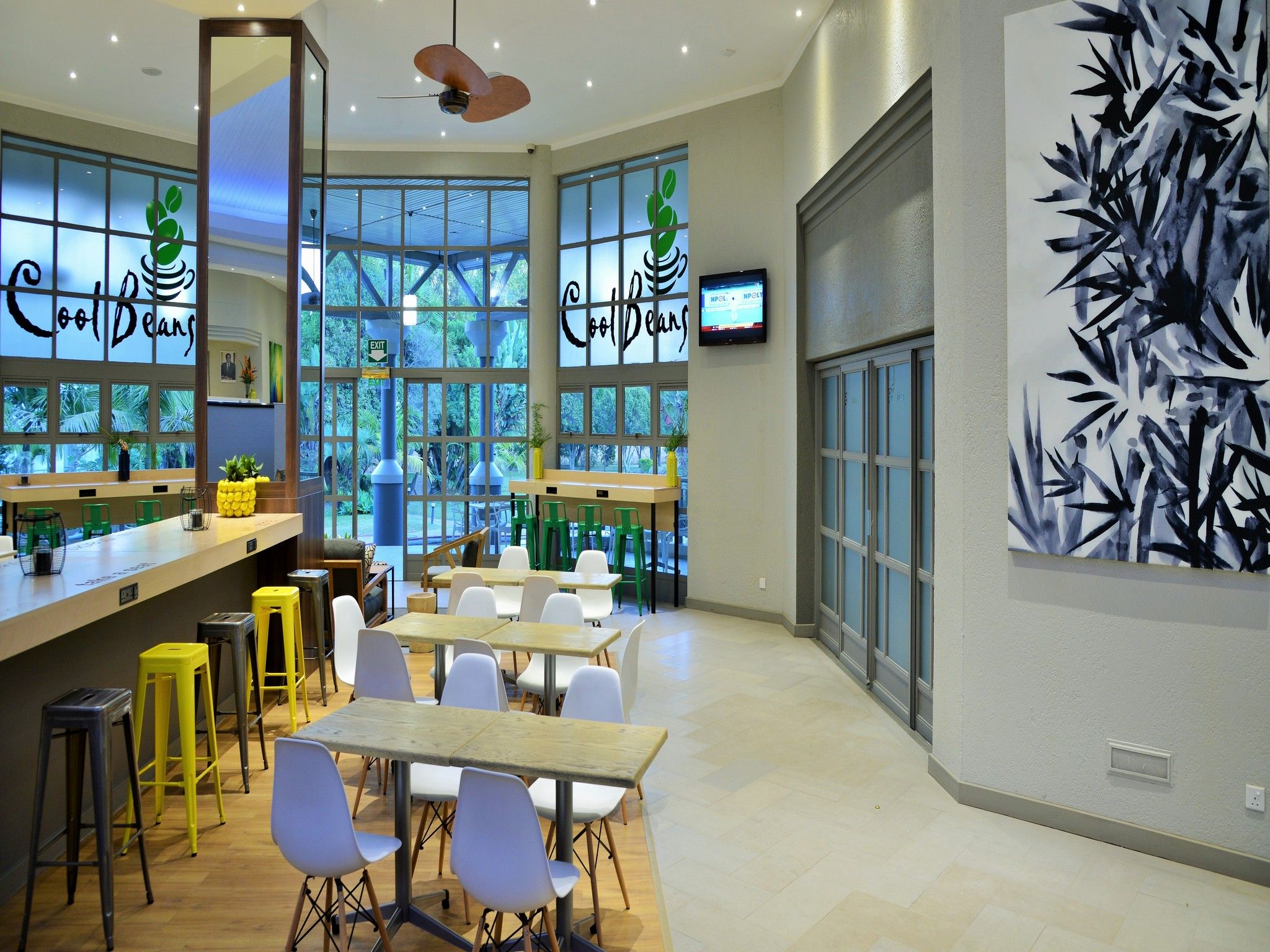 Un interior de cafetería moderno con una barra, asientos y ventanas amplias.