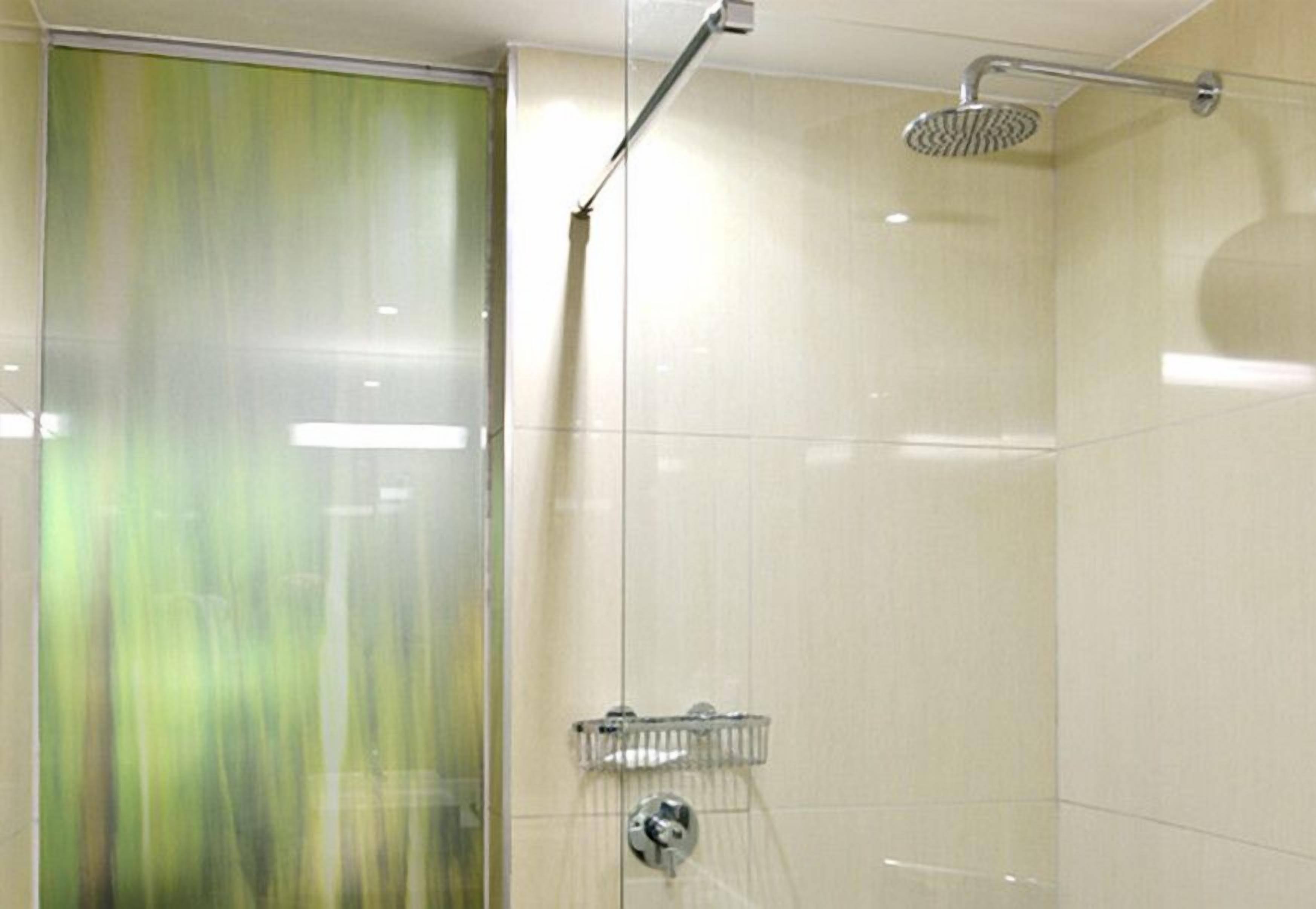 A shower with a handheld showerhead and a glass-enclosed shower area.