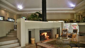 Un vestíbulo amplio con chimenea, zona de estar y una escalera que conduce a plantas superiores.