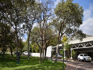Un estacionamiento con árboles y un edificio de diseño moderno.