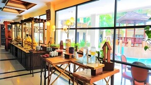 A hotel lobby with a long reception desk, large windows, and various decorative items. - Yusro Hotel Convention (Peterongan)