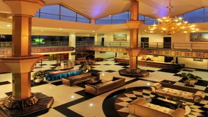 A spacious lobby with high ceilings, large pillars, and a checkered floor. - Yusro Hotel Convention (Peterongan)