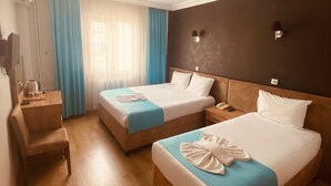 Een hotelkamer met twee bedden, een bureau en een stoel.