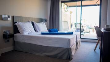 Une chambre d’hôtel avec un lit, un bureau et une vue sur l’extérieur.