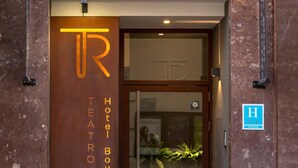 A hotel entrance with a sign reading "Hotel Boutique Teatro Romano".