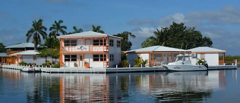 A waterfront property with a two-story building, a dock, and a boat.