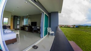 A modern hotel room with a balcony, a bed, a desk, and a TV. - SR Residence Hotel (Phetchabun)