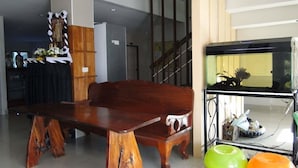 A room with a wooden bench, a sofa, and a fish tank. - Klangmuang River Home (Phetchabun)