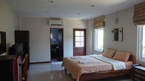 A bedroom with a bed, a desk, a TV, and an air conditioning unit. - Klangmuang River Home (Phetchabun)
