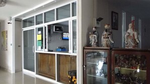 A spacious room with a large window, a television, and a cabinet with decorative items. - Klangmuang River Home (Phetchabun)