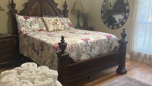 A bedroom with a wooden bed, a ceiling fan, a mirror, and a window with curtains. - Spacious - Private 2 brs, 2 baths (Charleston)