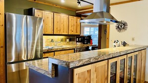 Eine moderne Küche mit Holzausstattung, Edelstahlgeräten und einer Arbeitsplatte aus Granit.