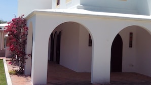 Un edificio blanco con múltiples cúpulas y paseos con arcos.